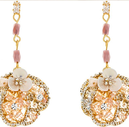 pendientes dorados en forma redonda con flor blanca