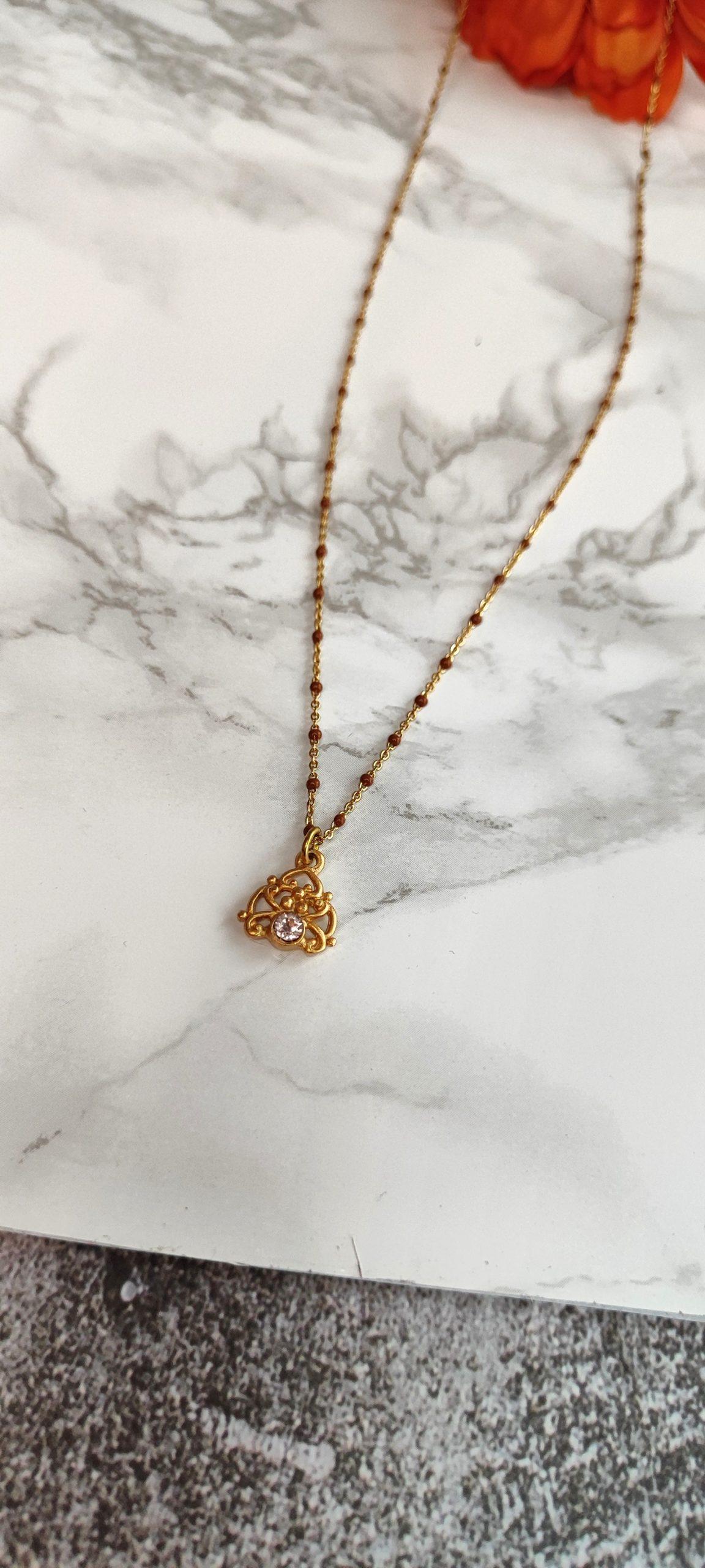 collar extra largo en acero dorado con diseño celta y cristal circonita