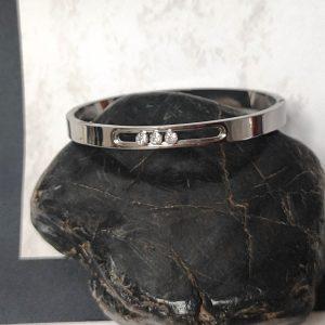 pulsera rígida ovalada en acero plateado con tres circonitas movibles
