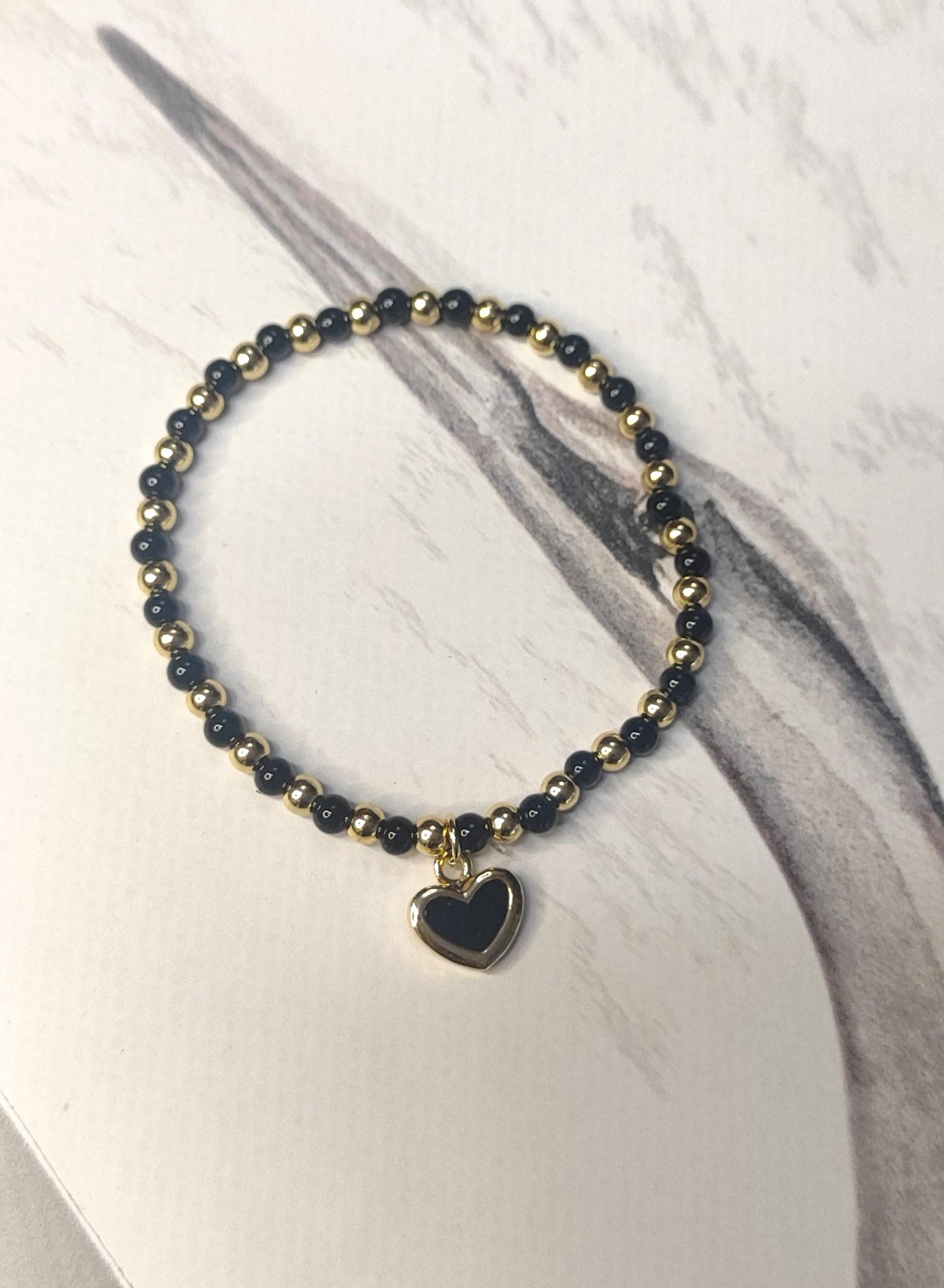 Pulsera elástica bolas doradas y mineral ónix con charm en forma de corazón